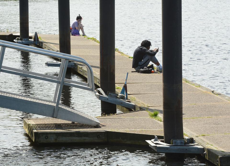 Ash Burnham, left, and Meikyle Murray, both of Norwich, relax on a floating dock Monday at Howard T. Brown Memorial Park in downtown Norwich. Repairs are planned in the 2022-2023 budget with 20% city and 80% state funding. 