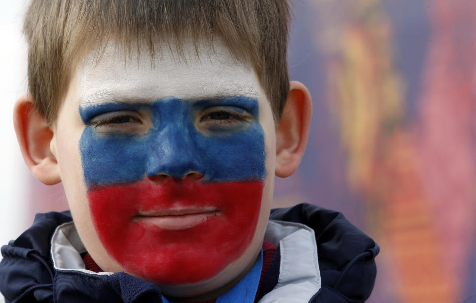 Limonov Egor Dmitrievich wears face paint in the colors of the Russian flag at the 2014 Winter Olympics, Sunday, Feb. 9, 2014, in Sochi, Russia.