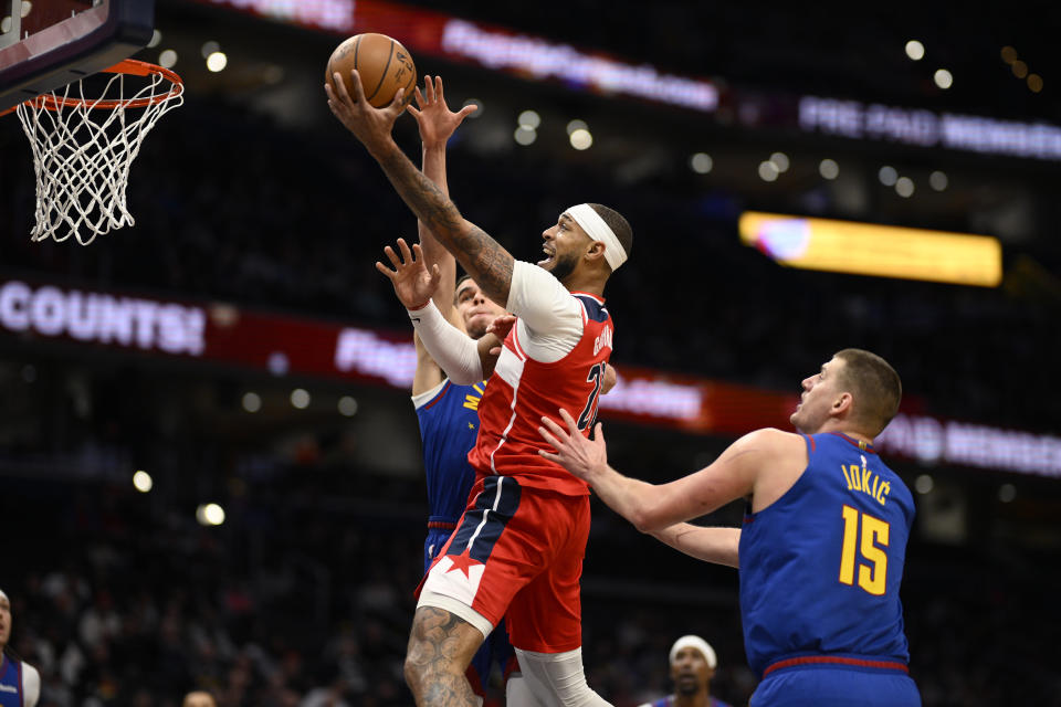 Washington Wizards center Daniel Gafford, front center, goes to the basket against Denver Nuggets center Nikola Jokic (15) and forward Michael Porter Jr., back center, during the first half of an NBA basketball game, Sunday, Jan. 21, 2024, in Washington. (AP Photo/Nick Wass)