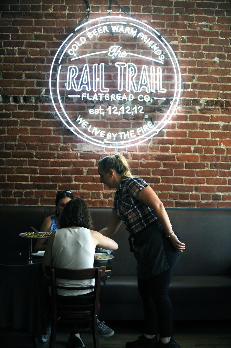 In Hudson, Rail Trail Flatbread Co. server Rachel Distler with diners in the new dining room area, July 15, 2021.