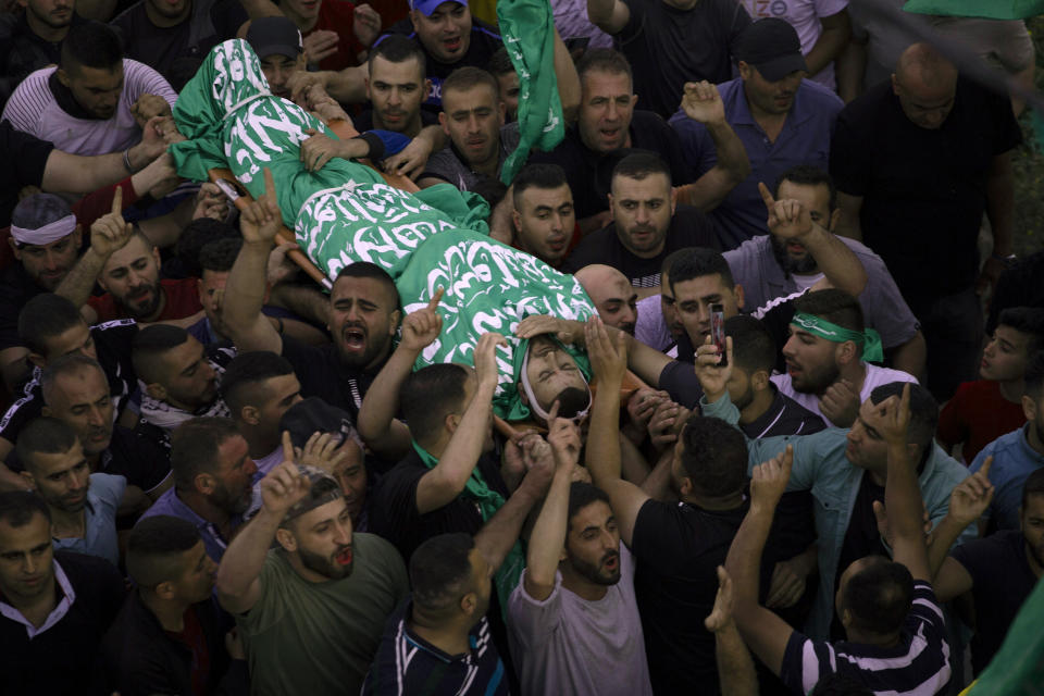 Palestinian mourners carry the body of Nidal Safadi, who was killed in clashes with Israeli forces, during his funeral in the West Bank village of Urif, near Nablus, Friday, May 14, 2021. (AP Photo/Majdi Mohammed)