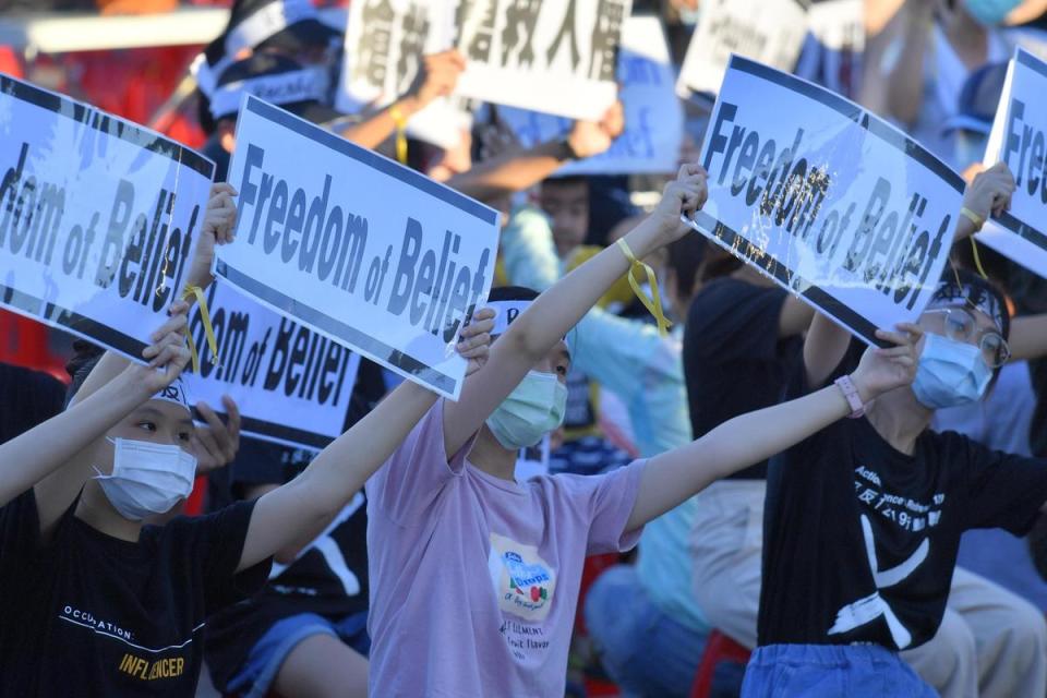 青少年總統府前舉抗議牌，要請總統救救人民。（太極門提供）