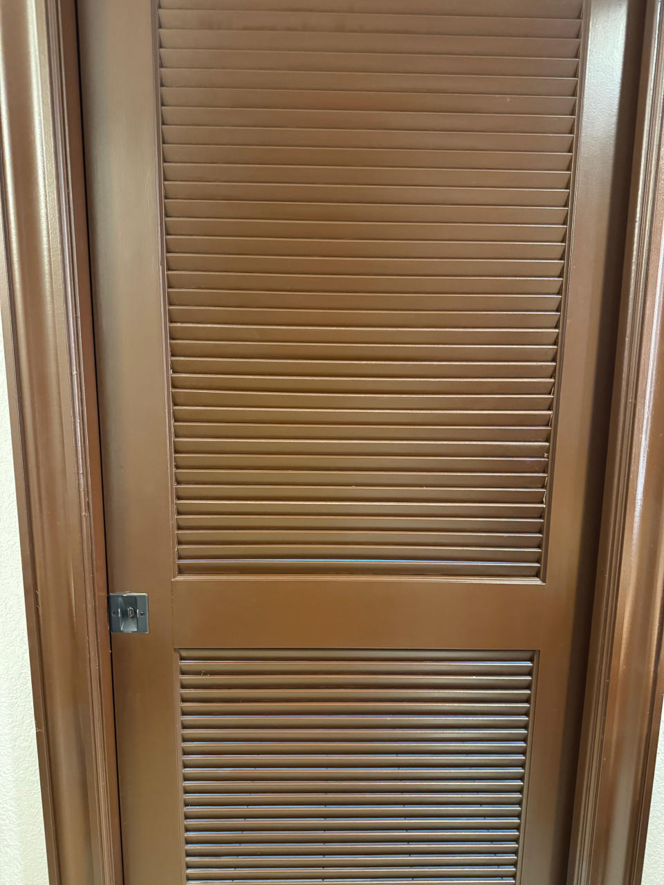 Brown door with horizontal slats, part of a building's interior architecture