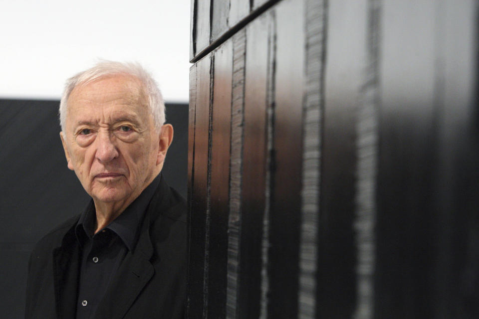 FILE - French painter Pierre Soulages poses next to one of his works at the Pompidou Center in Paris, Tuesday Oct. 13, 2009. French painter Pierre Soulages, who was famed for his use of black and was an icon of post-World War II European abstract art, has died, according to the Soulages Museum in his hometown. He was 102. (AP Photo/Remy de la Mauviniere, File)