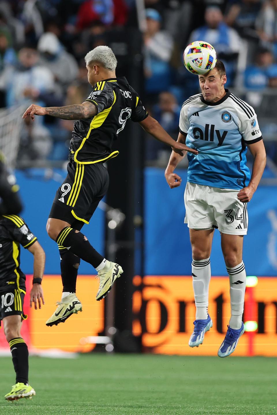 Charlotte midfielder Andrew Privett heads the ball against Crew forward Cucho Hernandez on Saturday.