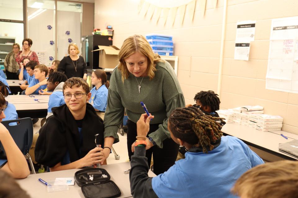 Patrick Williams (right), 14, holds a medical penlight for Quest teacher Pam Newtown to see during a MedStart presentation on Oct. 11. To the left is Caleb Hoyt, 13.