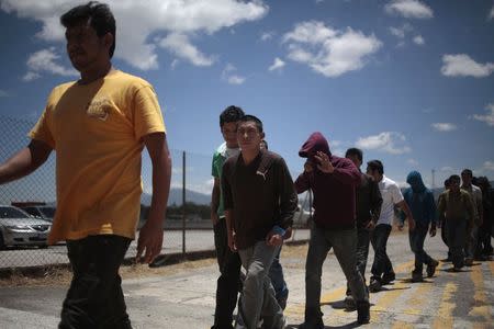 Illegal migrants from Guatemala, deported from Phoenix, Arizona in the U.S., walk after arriving at an air force base in Guatemala City July 22, 2014. The flight transporting the illegal Guatemalan migrants arrived on Tuesday after they were sent back from the U.S., according to immigration authorities. A growing wave of families and unaccompanied minors fleeing Guatemala, El Salvador and Honduras are streaming by the thousands into the United States by way of human trafficking networks through Mexico. REUTERS/Jorge Dan Lopez