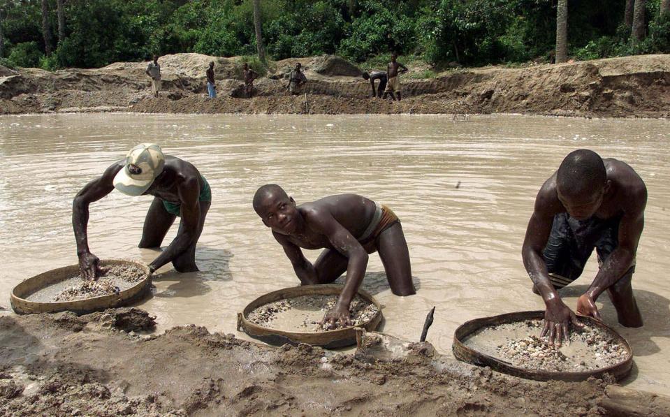 FILE- In this Wednesday May. 24, 2000 file photo, diamond prospectors sift through the earth in the Corbert mine in Waiima, Sierra Leone, 40 kilometers (25 miles) east of Bo in central Sierra Leone. A pastor in Sierra Leone's Kono district discovered and turned in the largest uncut diamond found in more than four decades in the West African country, the government said Thursday March. 16, 2017. (AP Photo/Adam Butler, File)