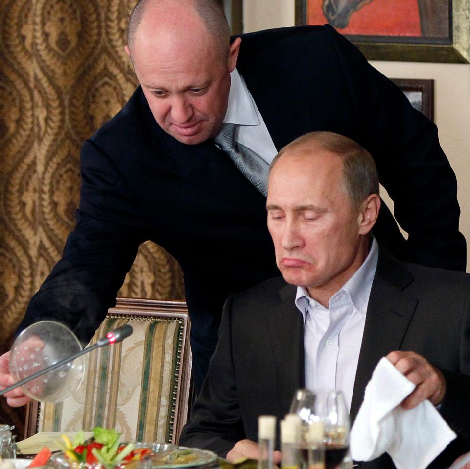 Yevgeny Prigozhin serves food to Validimir Putin at one of Prigozhin's Russian restaurants in 2011 - AP