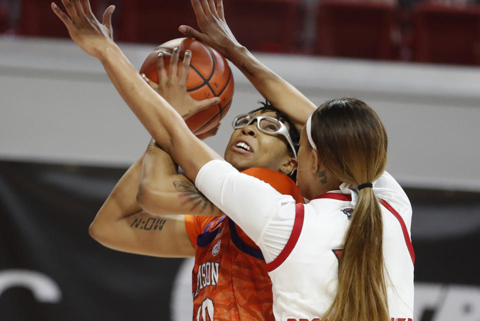 Clemson's Gabby Elliott (10) shoots as North Carolina State's Jakia Brown-Turner (11) defends during the first half of an NCAA college basketball game at Reynolds Coliseum in Raleigh, N.C., Thursday, Feb. 11, 2021. (Ethan Hyman/The News & Observer via AP)