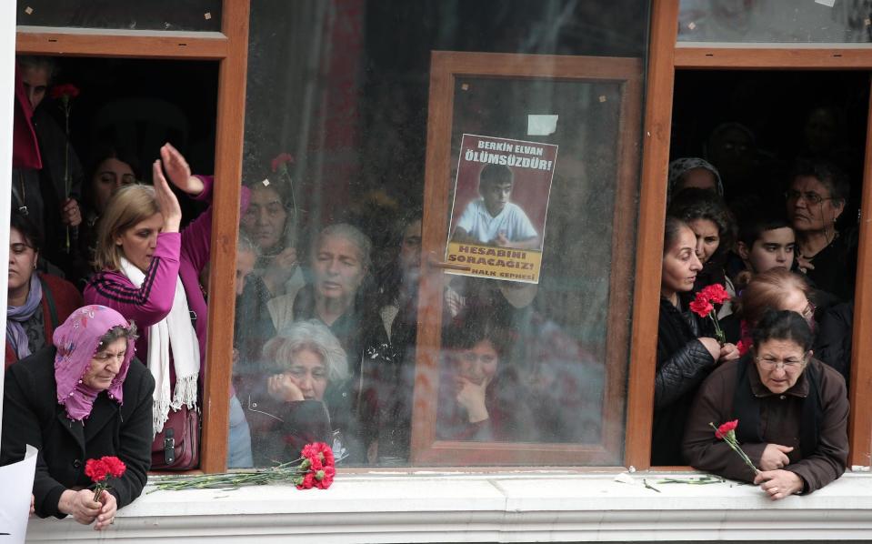 Family members watch as people carry the coffin of Berkin Elvan, a Turkish teenager who was in a coma since being hit on the head by a tear gas canister fired by police during anti-government protests in the summer of 2013, during his funeral in Istanbul, Turkey, Wednesday, March 12, 2014. On Wednesday, thousands converged in front of a house of worship calling for Prime Minister Recep Tayyip Erdogan to resign.(AP Photo/Emrah Gurel)