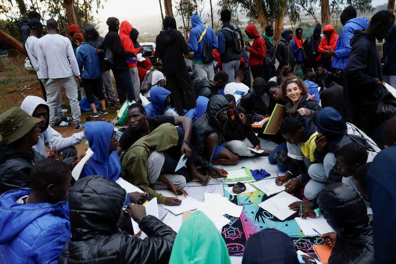 Several volunteers give Spanish classes to migrants outside the Las Raices Camp in La Laguna