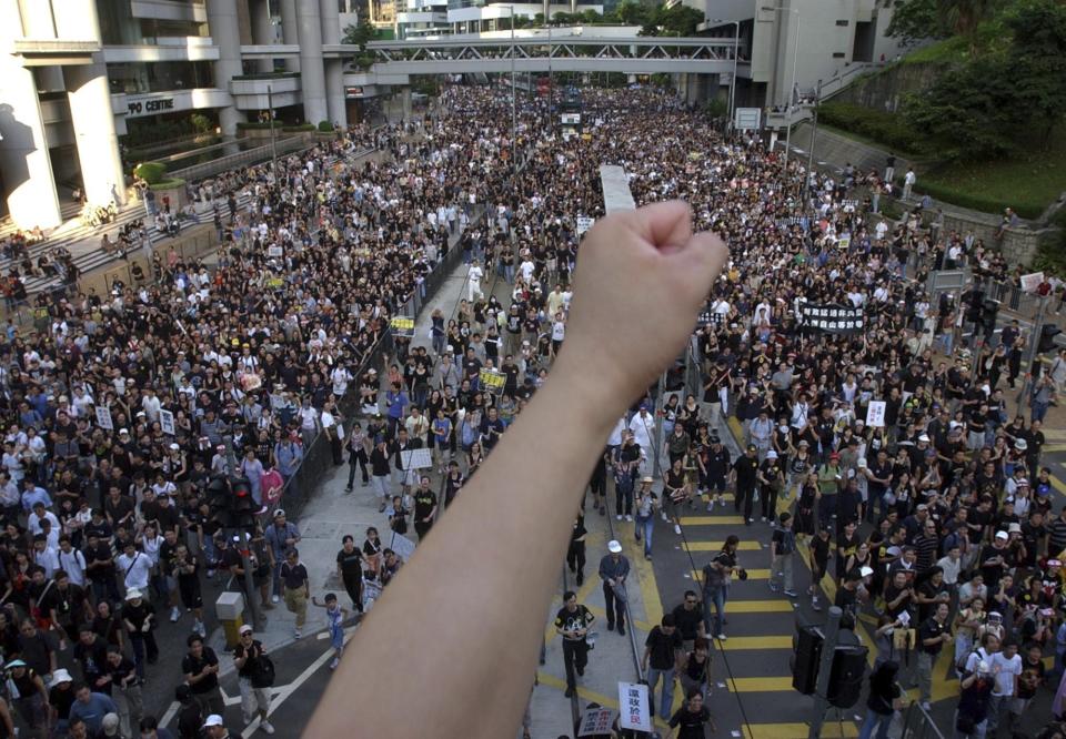 FILE - Tens of thousands of people march through a Hong Kong street Tuesday, July 1, 2003, to protest the Hong Kong government's plans to enact an anti-subversion bill that critics feared would curtail civil liberties. The bill was withdrawn after the march. Hong Kong’s plan to enact a new national security law, on top of a sweeping legislation that was imposed by Beijing and used to crack down on dissent, is deepening concerns over the erosion of freedoms in the former British colony.(AP Photo/Vincent Yu, File)