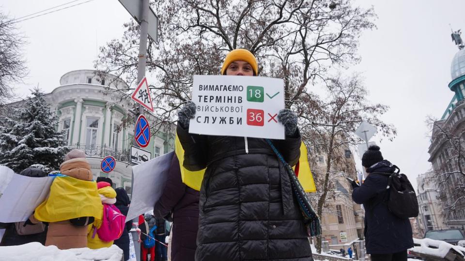 A woman holds a sign that demands soldiers be demobilized after 18 months, not 36 months. On Dec. 8, 2023, more than a hundred women gathered in downtown Kyiv to urge the government to demobilize their husbands. (Alexander Query/The Kyiv Independent)