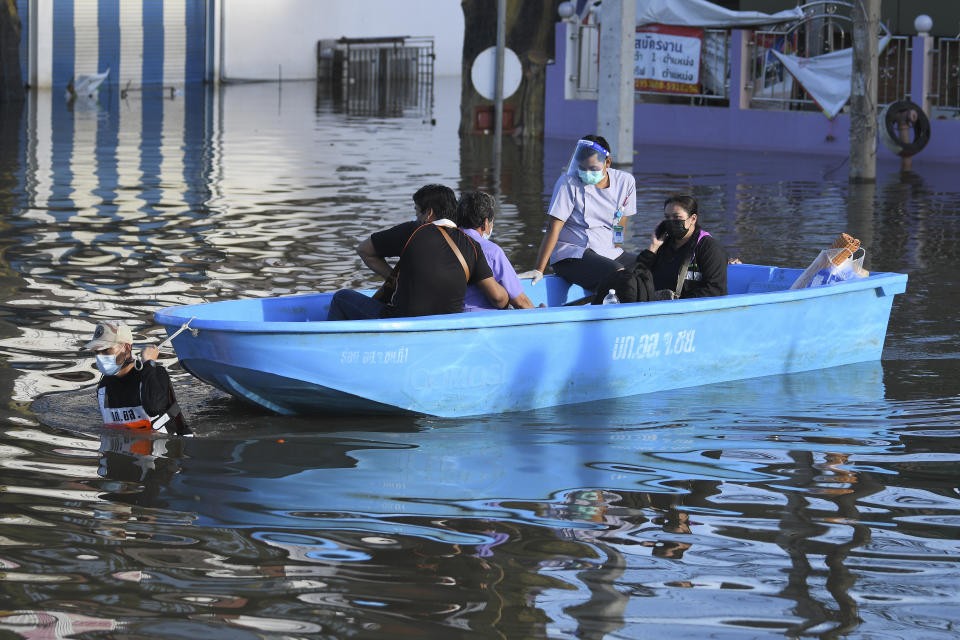 A Thai volunteer man pulls a boat carrying evacuees in a flooded area in Chaiyaphum province, northeast of Bangkok, Thailand, Tuesday, Sept. 28, 2021. Thai disaster officials say flooding caused by seasonal monsoon rains have affected more than 71,000 households in 30 provinces and killed six people since the weekend. (AP Photo/Thanachote Thanawikran)