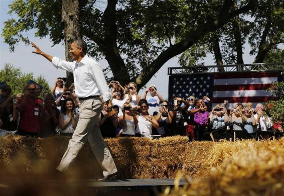 President Barack Obama waves during a campaign event at the Nelson Pioneer Farm and Museum in Oskaloosa, Iowa, August 14, 2012.