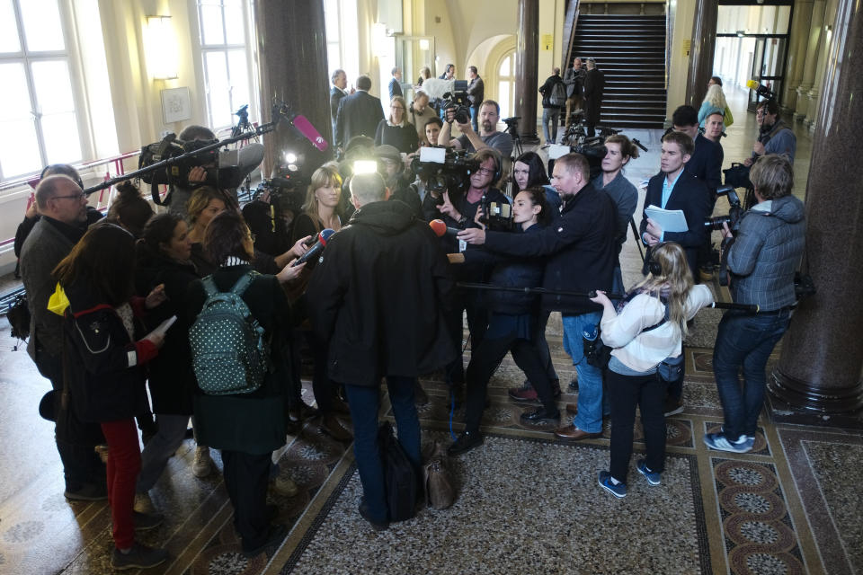 Reporters surround Stefan Waterkamp, center, lawyer, of 93-year-old former SS private Bruno Dey, as he briefs the media at the criminal court in Hamburg, Thursday, Oct. 17, 2019. The former SS guard Bruno Dey going on trial at the court on 5,230 counts of being an accessory to murder, accused of helping the Nazis' Stutthof concentration camp function. (AP Photo/Markus Schreiber)