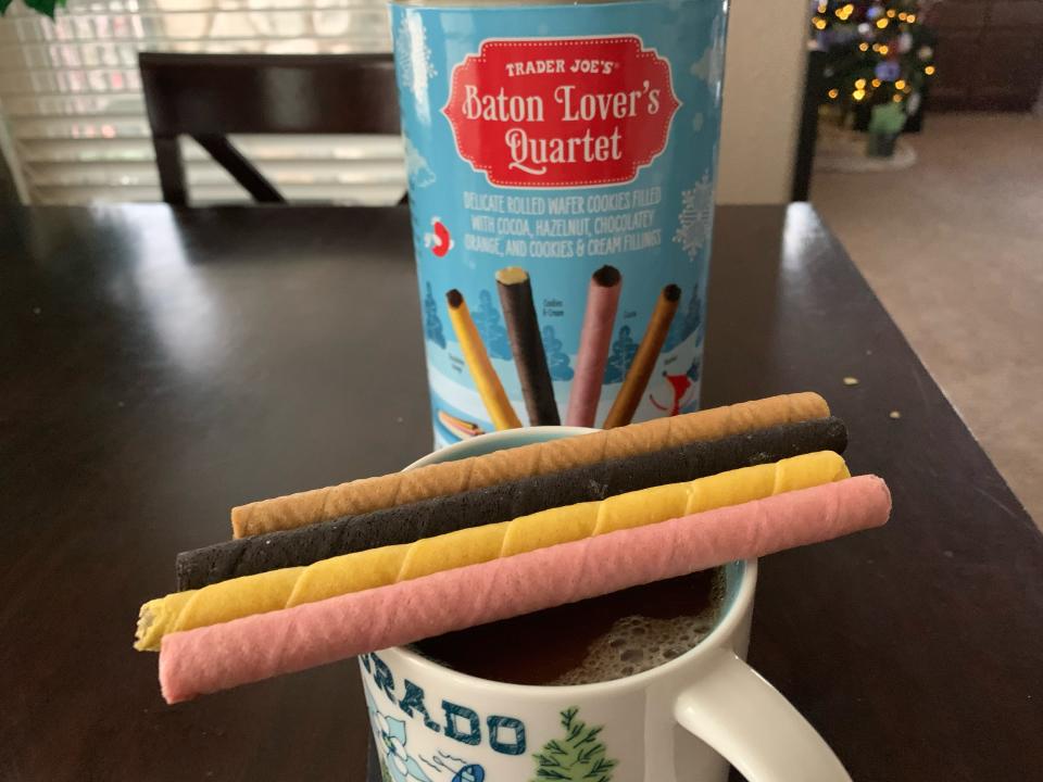 blue package of trader joe's batons behind mug with the four flavors on top of it