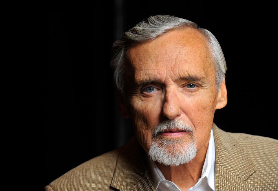 dennis hopper, wearing a tan suit, looking directly into the camera