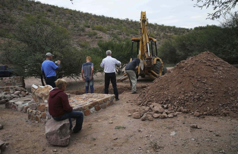 Men stand around a grave being dug for several of the women and children related to the extended LeBaron family who were killed by drug cartel gunmen, before their burial at the cemetery in La Mora, Sonora state, Mexico, Thursday, Nov. 7, 2019. Three women and six of their children were gunned down in an attack while traveling along Mexico&#39;s Chihuahua and Sonora state border on Monday. (AP Photo/Marco Ugarte)