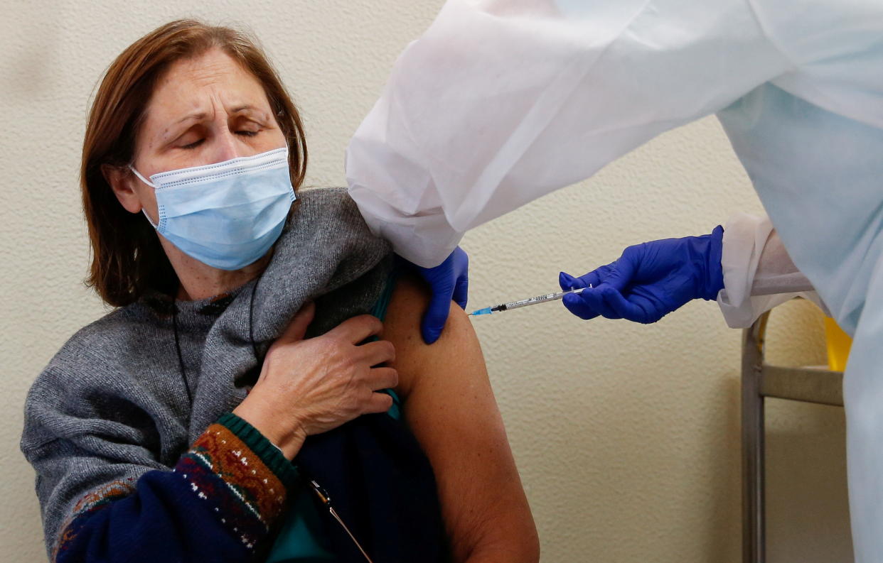 A woman receives the Pfizer-BioNTech coronavirus disease (COVID-19) vaccine at Santa Maria hospital in Lisbon, Portugal, December 27, 2020. REUTERS/Pedro Nunes     TPX IMAGES OF THE DAY