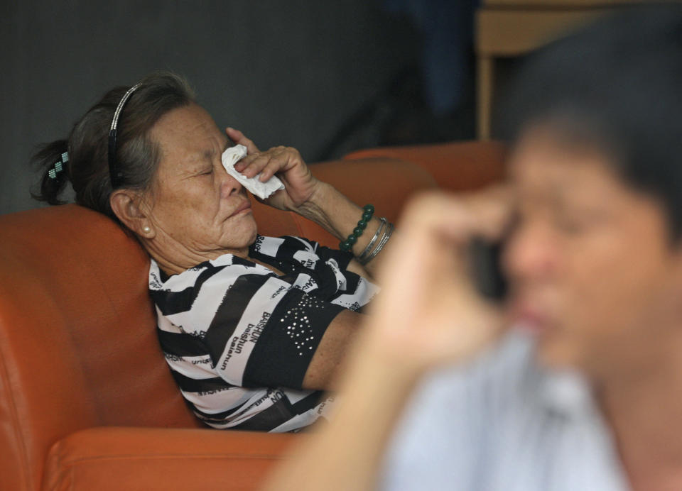 Suwarni the mother of Sugianto Lo, who was onboard the Malaysia Airlines plane MH370 with his wife Vinny, weeps as an unidentified relative makes a phone call at her residence in Medan, North Sumatra, Indonesia, Tuesday, March 25, 2014. After 17 days of desperation and doubt over the missing Malaysia Airlines jet, the country's officials said an analysis of satellite data points to a "heartbreaking" conclusion: Flight 370 met its end in the southern reaches of the Indian Ocean, and none of those aboard survived. (AP Photo/Binsar Bakkara)