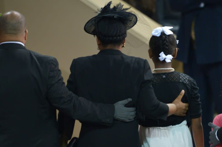 The wife of South Carolina State Sen. and Rev. Clementa Pinckney, Jennifer, stands with her daughter before US President Barack Obama delivers the eulogy during the funeral of slain Clementa Pinckney in Charleston, South Carolina on June 26, 2015