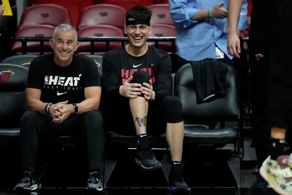 Miami Heat guard Tyler Herro, right, laughs as he watches from the bench during a practice ahead of Game 3 of the NBA Finals, at the Kaseya Center in Miami, Tuesday, June 6, 2023. (AP Photo/Rebecca Blackwell)