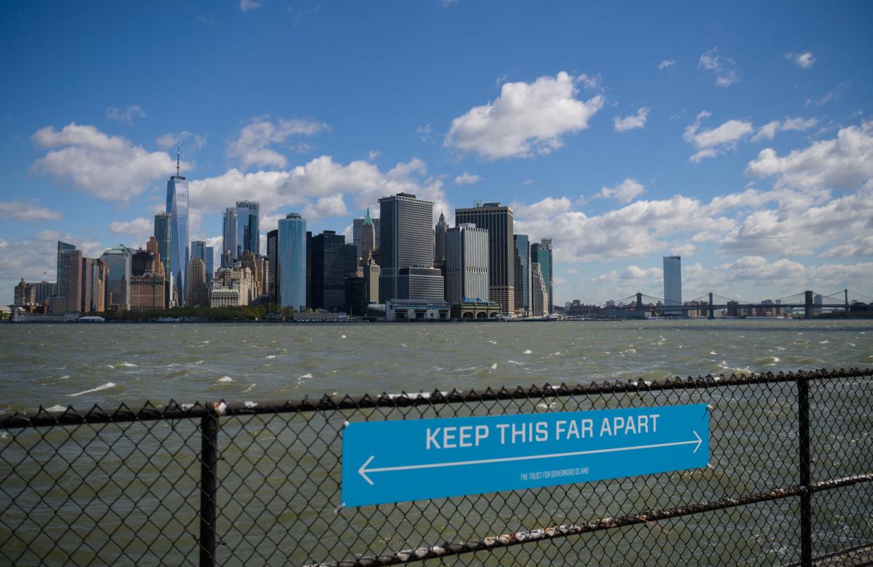 <p>A sign to promote social distancing is seen on Governors Island, New York</p> (AFP via Getty Images)