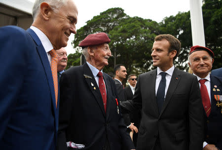 French President Emmanuel Macron speaks with former serviceman Bill Mackay, who he earlier presented with a Legion d'Honneur award, as Australian Prime Minister Malcolm Turnbull looks on after a Commemorative Service at the ANZAC war memorial in Sydney May 2, 2018. AAP/David Moir/via REUTERS