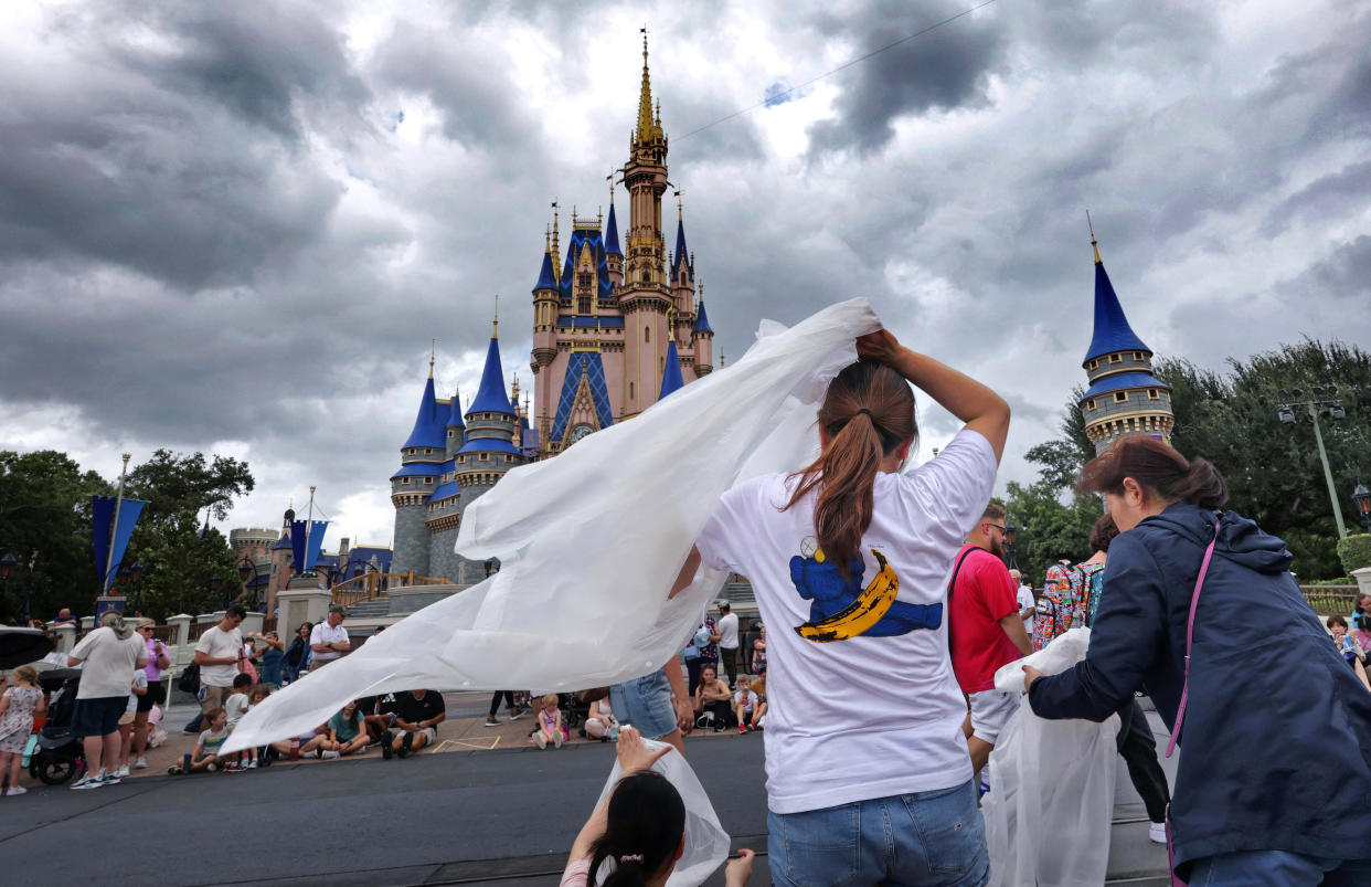 Guests at the Magic Kingdom break out ponchos at Cinderella Castle as bands of weather from Hurricane Helene move through Walt Disney World in Bay Lake, Florida, on Sept. 26, 2024. (Joe Burbank/Orlando Sentinel/Tribune News Service via Getty Images)