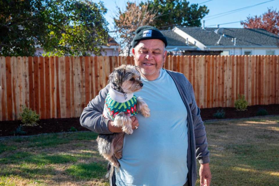 Vietnam veteran Rick Sanchez holds his dog Joey in their backyard in south Sacramento on Dec. 8. Habitat for Humanity helped him with fencing, landscaping, a new overhang and painted his home. The organization is asking Book of Dreams readers to support its program that helps needy veterans with home upgrades and repairs. José Luis Villegas/Special to The Bee