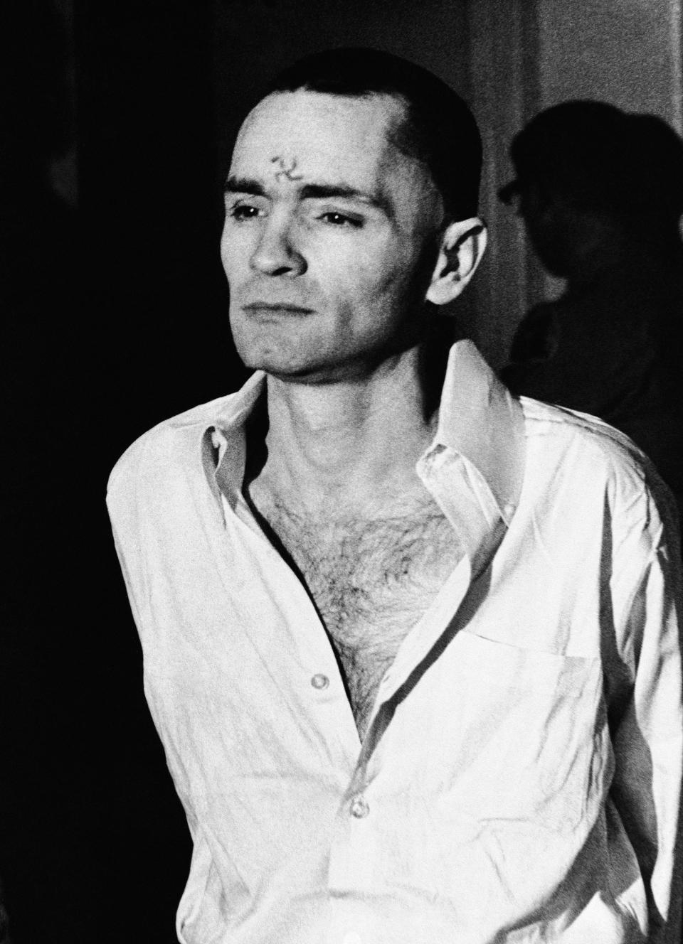 <p>Charles Manson, clean-shaven and with a swastika scratched on his forehead, walks to court, March 12, 1971, in Los Angeles, for a hearing in the penalty phase of the trial. (Photo: AP) </p>