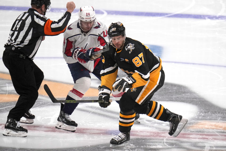 Pittsburgh Penguins' Sidney Crosby (87) gets a high stick to the face from Washington Capitals' Connor McMichael (24) on a face-off during the first period of an NHL hockey game in Pittsburgh, Thursday, March 7, 2024. (AP Photo/Gene J. Puskar)