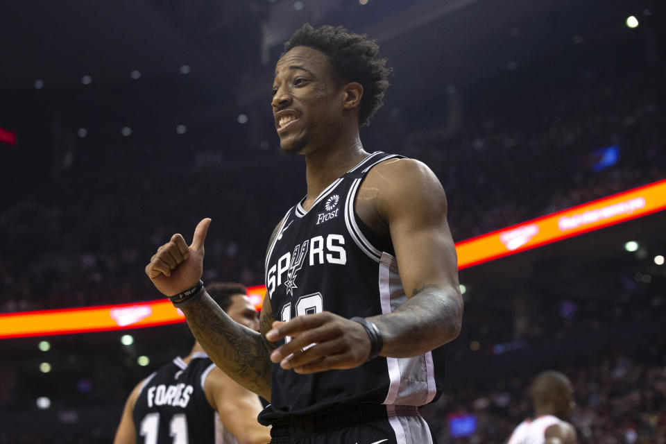 San Antonio Spurs' DeMar DeRozan shares a joke with the Toronto Raptors bench during the first half of an NBA basketball game in Toronto on Sunday, Jan. 12, 2020. (Chris Young/The Canadian Press via AP)