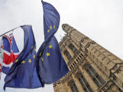 Flags of Anti Brexit protestors fly in front of parliament in London, Wednesday, Oct. 23, 2019. Britain's government is waiting for the EU's response to its request for an extension to the Brexit deadline. (AP Photo/Frank Augstein)