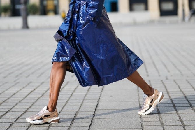 Woman wearing trench coat and chunky sneakers