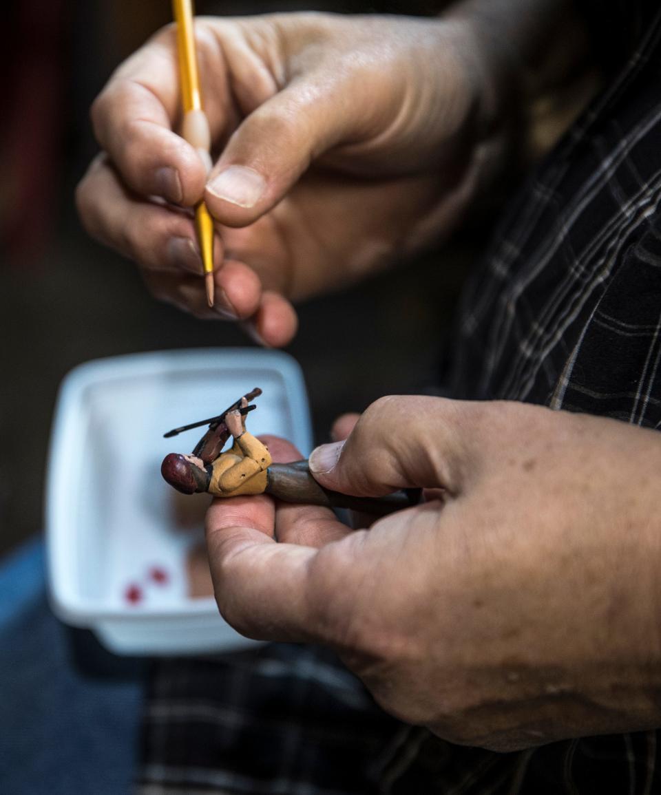 Artist Steve Armstrong paints a tiny figure which will be part of one of his kinetic motion sculptures in his Kentucky studio. Dec. 27, 2021.