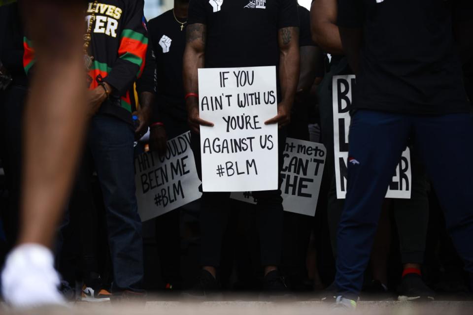 A Denver Broncos player holds a sign while joining thousands of people protesting the death of George Floyd on June 6, 2020 in Denver, Colorado. This is the 12th day of protests since George Floyd died in Minneapolis police custody on May 25. (Photo by Michael Ciaglo/Getty Images)