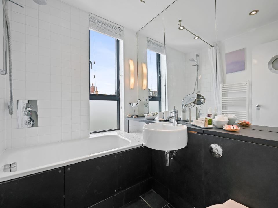 A black and white bathroom inside of a skinny home in london