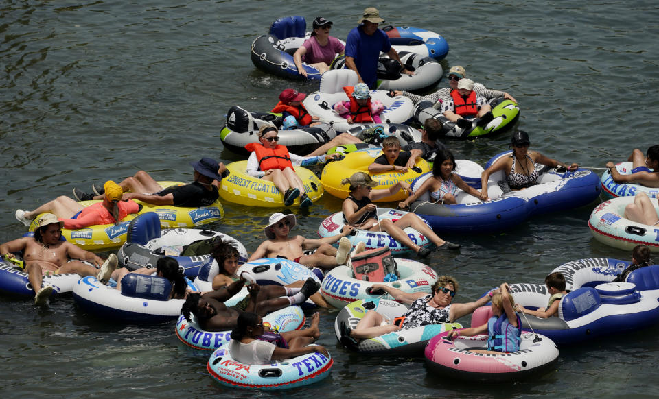 Tubers float the Coral River, Tuesday, June 14, 2022, in New Braunfels, Texas. The summer of 2022 can feel as if the coronavirus pandemic is really over. Mask rules and testing requirements are lifting in many countries, including the United States. (AP Photo/Eric Gay)