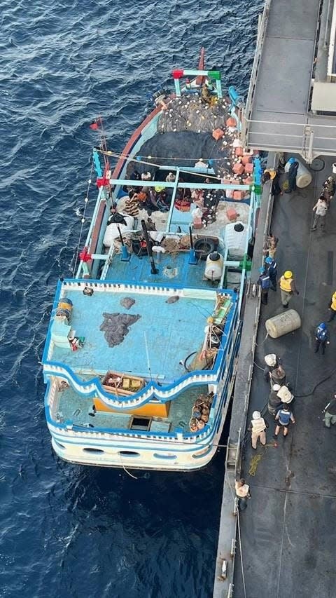 a dhow brought alongside the a larger military ship