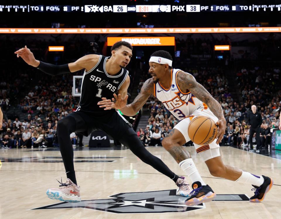 Bradley Beal (3) of the Phoenix Suns drives on Victor Wembanyama (1) of the San Antonio Spurs in the first half at Frost Bank Center on March 23, 2024, in San Antonio, Texas.