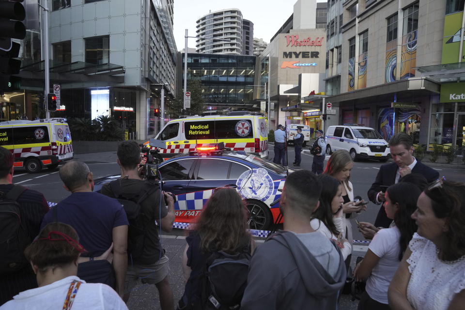 A crowd gathers outside Westfield Shopping Centre in Sydney, Saturday, April 13, 2024. Media reports say multiple people have been stabbed and that the police shot a person at the Sydney shopping center. (AP Photo/Rick Rycroft)