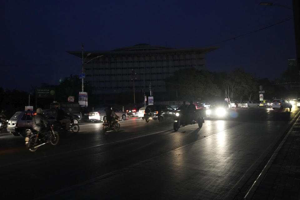Motorcyclists and cars drive on a road during a national-wide power breakdown, in Lahore, Pakistan, Monday, Jan. 23, 2023. Much of Pakistan was left without power Monday as an energy-saving measure by the government backfired. The outage spread panic and raised questions about the cash-strapped government's handling of the country's economic crisis. (AP Photo/K.M. Chaudary)