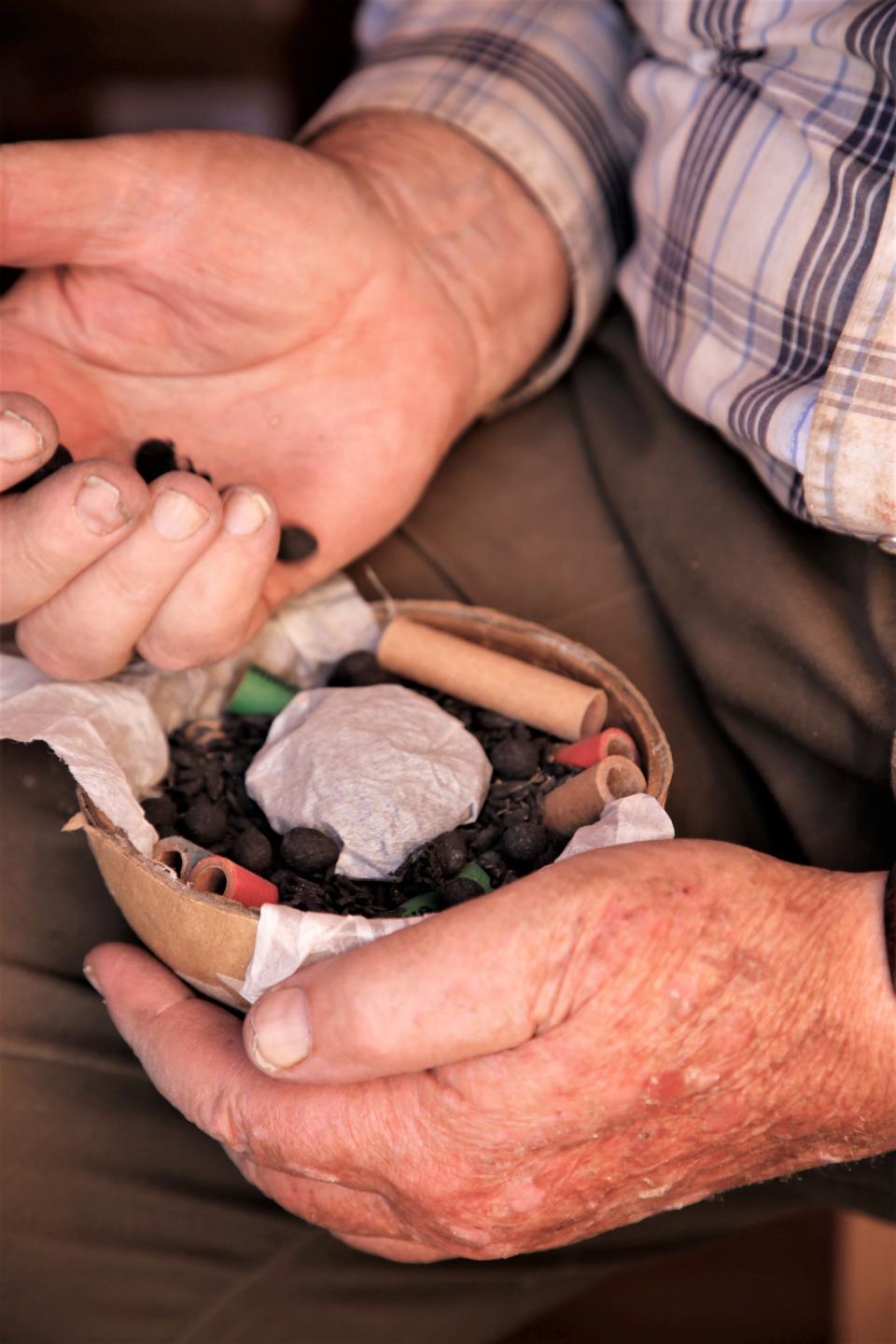 Tommy Bolack drops in additional material around a packet of initializer in the center of the bottom half of a 6-inch shell as he prepares for his annual Fourth of July fireworks show from the B-Square Ranch.