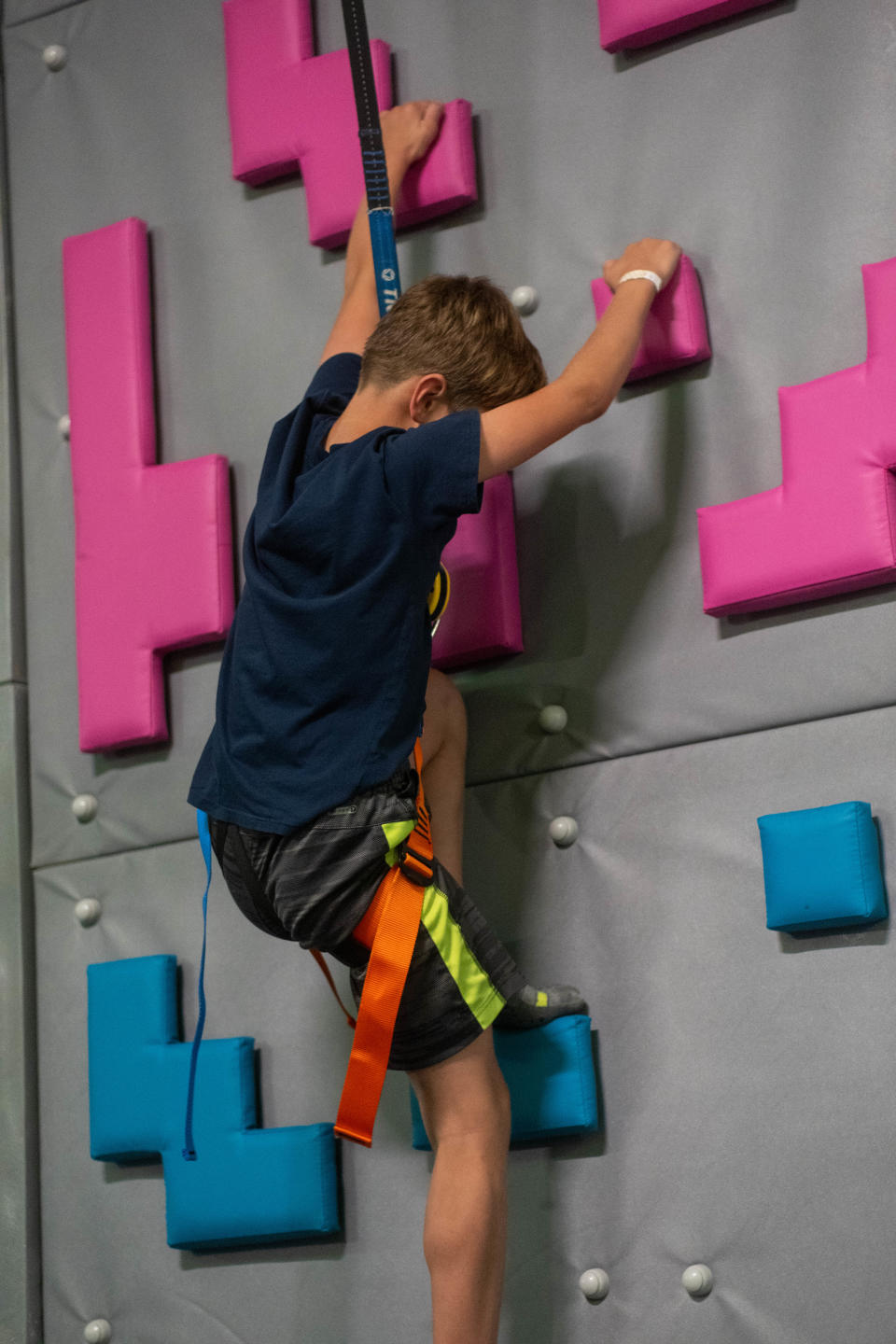 A young boy scales the rock climbing wall at Urban Air Adventure Park in Amarillo.