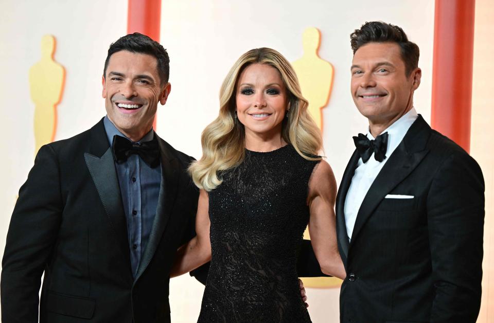 Kelly Ripa with her ghost of co-host present, husband Mark Consuelos, and ghost of co-host past, Ryan Seacrest, at the Oscars on March 12.