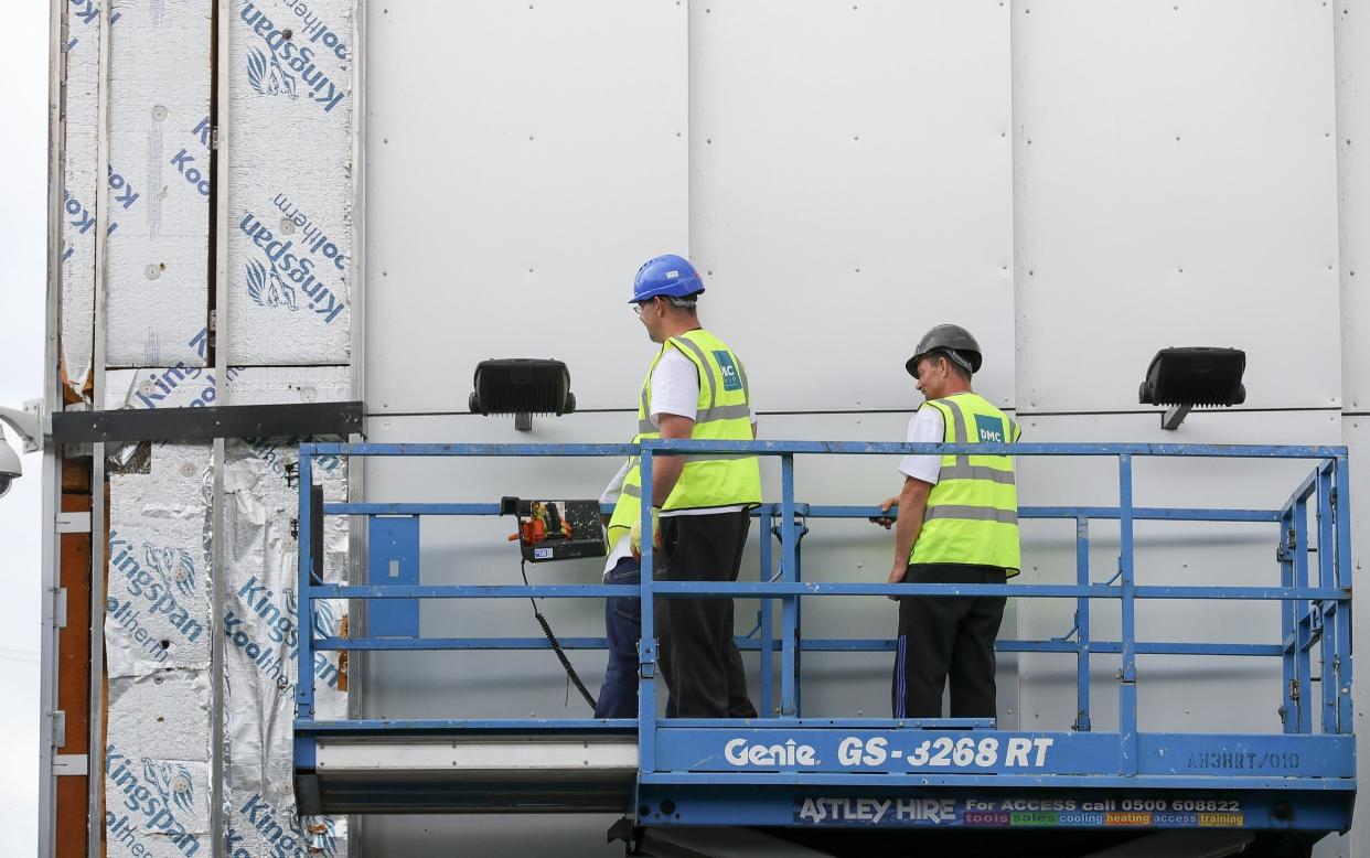 Workers removing cladding for testing from a tower block in Salford City in June 2017, shortly after the fire - Getty Images