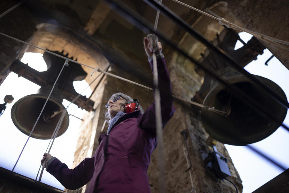 Roser Reixach, a student of the Vall d'en Bas School of Bell Ringers, performs playing a bronze bell at the church bell tower of the12th-century Sant Romà church, at the tiny village of Joanetes, about two hours north of Barcelona, Spain, Saturday, July 29, 2024. A school set up to revive the manual ringing of church bells has graduated its first class of 18 students after learning their ringing skills. (AP Photo/Emilio Morenatti)